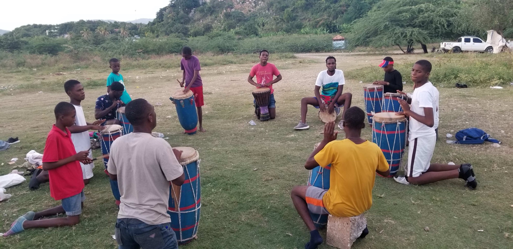 Sing for Hope students in a drumming circle outdoors